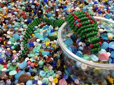 Green crocs beside a heap of loose beads