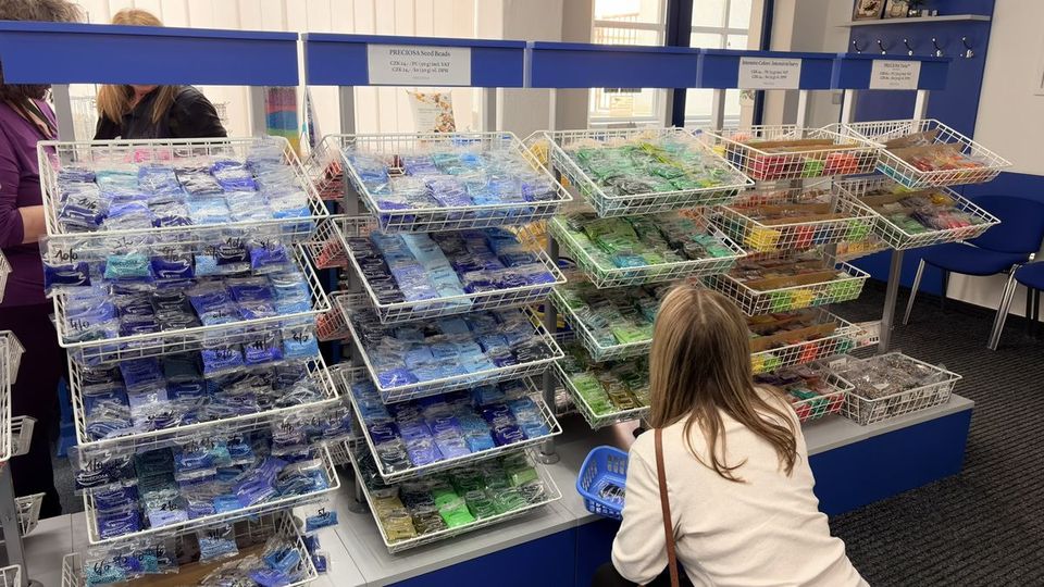 Shopper with a basket in a Preciosa seed-bead aisle