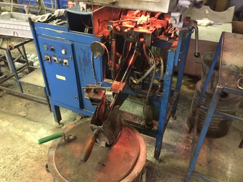 Red-hot glass in a bead-pressing machine