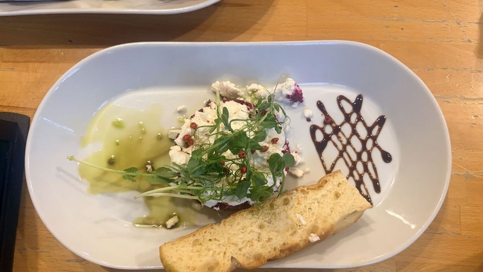 Beetroot tartare topped with crumbled goat’s cheese, pea shoots and pink peppercorns, with olive oil, balsamic and toasted bread