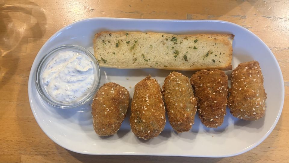 Five sesame-crumbed croquettes with a creamy herb dip and a slice of garlic bread